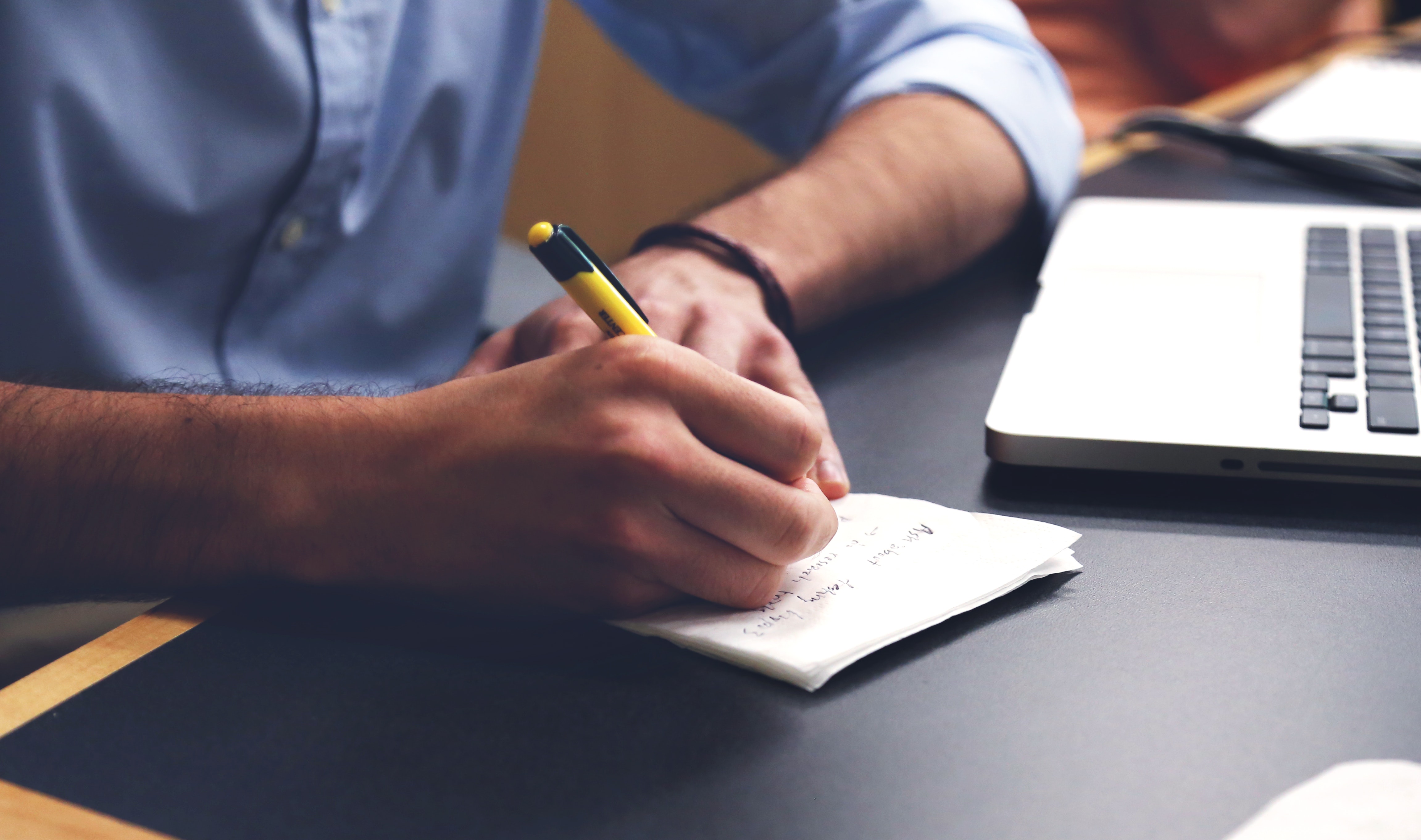 Hand Writing Notes at a Desk